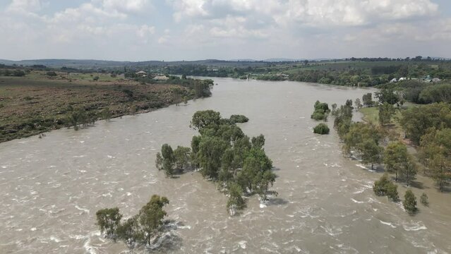 Low aerial flyover of high turbid river water in spring flood