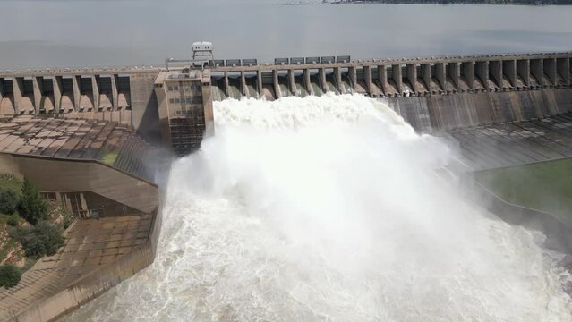 Low aerial tilts to hydro dam spillways releasing flood water from dam