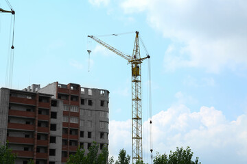 Fototapeta premium Construction site with tower crane near unfinished building
