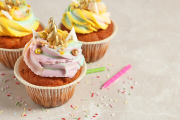 Cute sweet unicorn cupcakes on beige marble table, closeup. Space for text