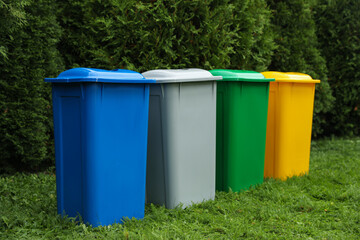 Many color recycling bins on green grass outdoors