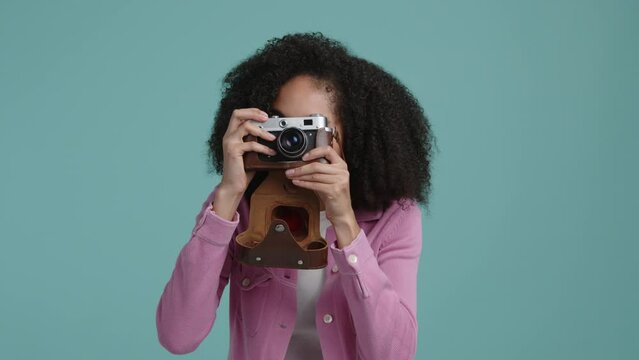 Cheerful, smiling girl during the session in colorful studio. Portrait of a woman taking photos with a camera. High quality 4k footage