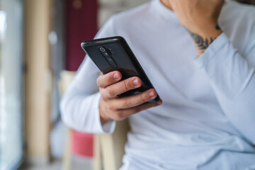 A young businessman in cafe using his laptop mobile phone and wireless earbuds while working on his project business on his laptop and talking on the phone 