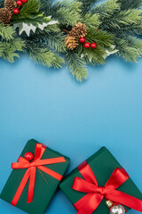 Flat lay composition with gift boxes and Christmas decorations on blue background, space for text. Christmas concept.