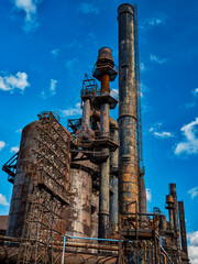 Vertical image of the rusting and flaking smoke stacks and plumbing and piping at the abandoned Bethlehem Steel Works in Pennsylvania - 551421385