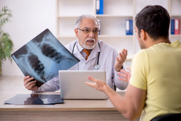 Fototapeta premium Young male patient visiting old male doctor