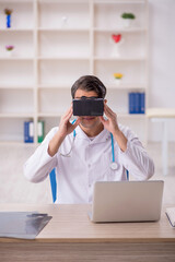 Young male doctor enjoying virtual glasses at the hospital