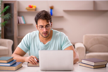 Young male student preparing for exams at home