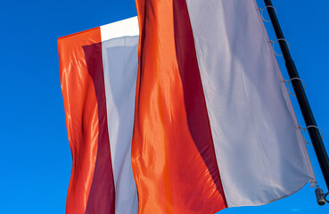 Polish flags against blue sky. Flags of Poland on the wind. Independence day celebration