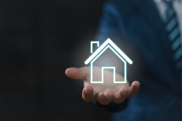 Fototapeta na wymiar Real estate concept: a businessman holding an icon of a house. house available Property insurance and security concept Man protective gesture and house symbol