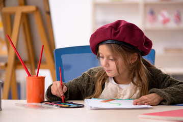 Young little girl enjoying painting at home