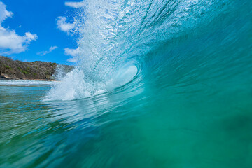 Tubular wave breaking into the crystalline emerald green sea