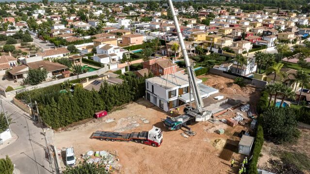Hyperlapse of crane stacking modules for construction of prefabricated building. Aerial backward ascending