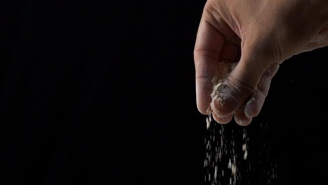 A young woman sprinkling fresh wheat flour - food ingredient  Indian staple . Atta / flour particles against a black background - Indian kitchen  Corn powder