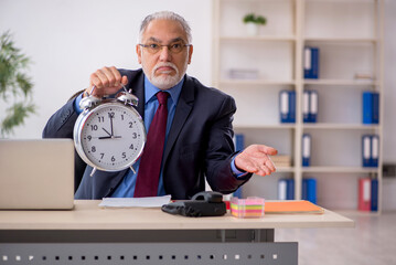 Old male employee in time management concept