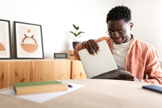 Black Male High School Teen Student Removing Laptop Out Of Backpack To Start Studying At Home. Copy Space.