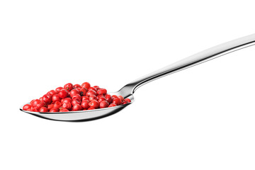 Teaspoon with whole red pepper peppercorns isolated on white.
