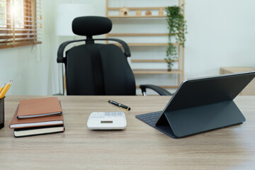 Fototapeta premium Tablet computer, notebook, calculator and coffee cup on the desk in the office