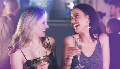 Friends, drinks and party at nightclub to celebrate champagne glass, happiness and new years or birthday energy with funny conversation. Girls at club, event or disco for happy hour celebration