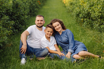 Fototapeta premium Young family looking at the camera while walking in the garden