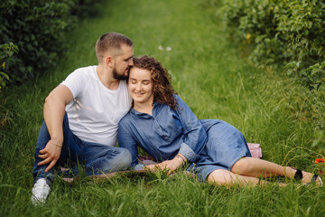 Naklejka na ściany i meble young couple sitting on grass and relaxing