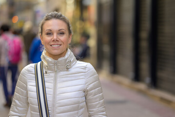 Joyfully laughing woman walking through a shopping street