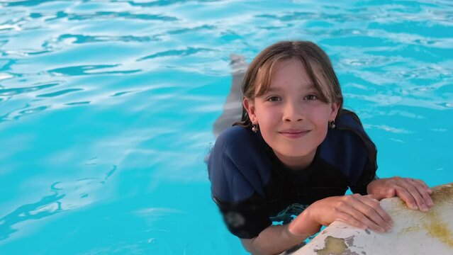 Portrait of a girl, swimming at outdoor pool.