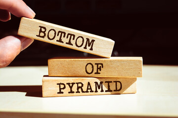 Wooden blocks with words 'Bottom of the Pyramid'.