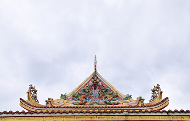 Fototapeta premium BANGKOK, THAILAND - December 03, 2022 : Part of the Roof of chinese temple in Thailand. Traditional Chinese style pattern on the roof of a temple with Blue Sky Background.