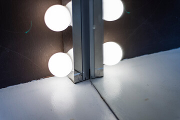 Fototapeta na wymiar Light bulbs in a row reflected on a mirror edge in a camerino