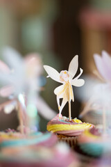 Paper toy ballet fairy decoration on many colourful muffin cakes