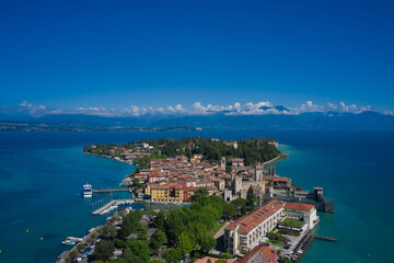 View of the Italian town of Sirmione and Lake Garda. Aerial view on Sirmione sul Garda. Italy, Lombardy.  Rocca Scaligera Castle in Sirmione. Aerial photography with drone.
