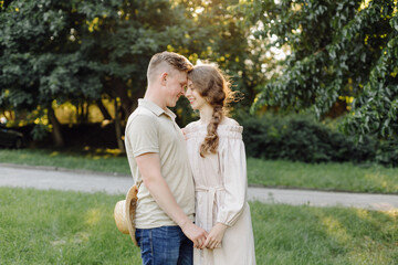 Fototapeta premium Young couple in love outdoor.Stunning sensual outdoor portrait of young stylish fashion couple posing in summer in field