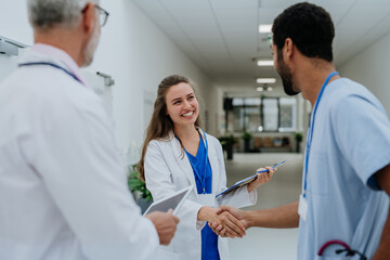 Doctors greetings and shaking hands at hospital corridor.