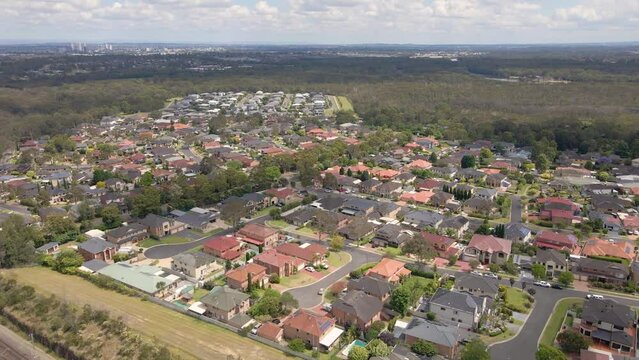 Aerial drone view of Voyager Point in South West Sydney, NSW Australia showing development of housing and parks with Liverpool CBD in the distant background   