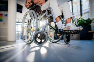 Close-up of wheelchair with senior woman at hospital corridor. - obrazy, fototapety, plakaty
