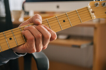 Closeup of male hands playing the electric guitar