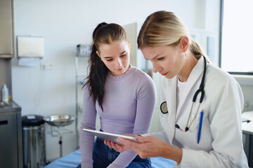 Young woman doctor explaining diagnosis to teenage girl in her ambulance.