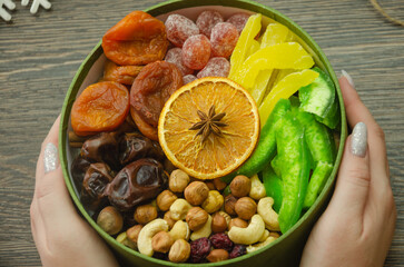 box with nuts and dried fruits to hold in your hands, on the table Christmas decorations