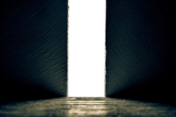 Bright light between two walls. Light from the opening large stone gate, portal. A light in the end of a tunnel. The concept of success, freedom of choice, open mind, meditation.