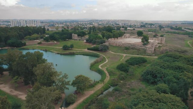 Aerial slide over a beautiful lake with fortress ruins in the background  - Tel Afek National Park #001