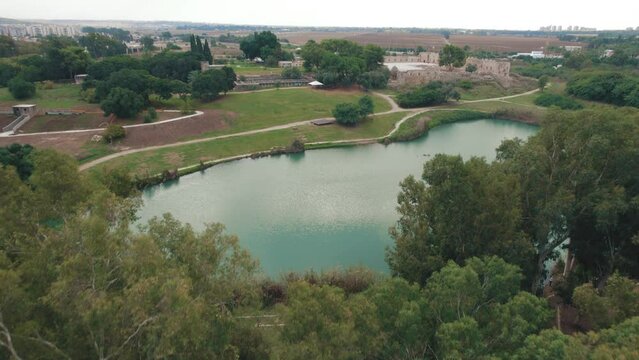 Beautiful lake with fortress ruins in the background  - Tel Afek National Park - Aerial view tilt down  #010