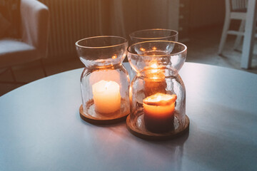 Three candles in jars on living room table