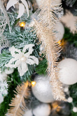 Close-up of white and silver decorations on a Christmas tree