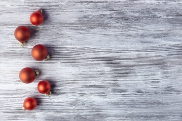 Naklejka na ściany i meble Red Christmas balls over aged craft wooden background with copy space. Xmas and New Year background