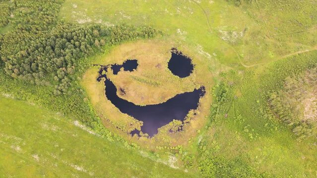 Aerial view of an exotic lake that seems to be laughing slyly. A pond with big eyes. The beauty of nature. A joyful expression on a natural lake. Happy nature smiles. 4K UHD.