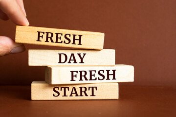 Wooden blocks with words 'Fresh day, fresh start'.