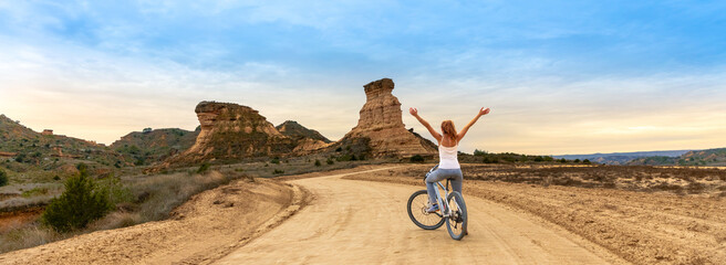 Woman in bike in Monegros desert,  Aragon in Spain