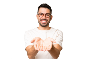 Young handsome caucasian man over isolated chroma key background holding copyspace imaginary on the palm to insert an ad