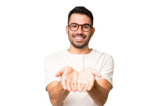 Young handsome caucasian man over isolated chroma key background holding copyspace imaginary on the palm to insert an ad